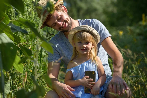 Padre y Niña usando un teléfono móvil en el campo . — Foto de Stock
