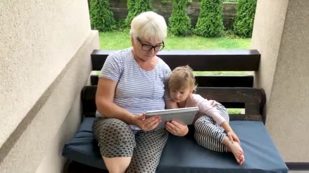 Bonne grand-mère et petite-fille en utilisant la tablette numérique — Video