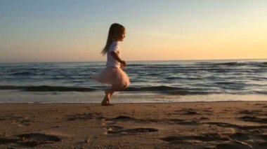 Gün batımında sahilde küçük kız çalışan yavaş hareket.