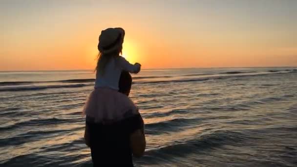 Πατέρας και κόρη που τρέχει κατά μήκος της παραλίας στο ηλιοβασίλεμα. — Αρχείο Βίντεο