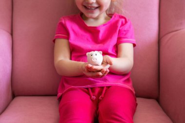 Küçük eller pembe domuz kumbarasını tutuyor.