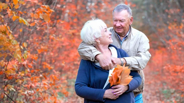 Feliz pareja mayor en un parque de otoño — Foto de Stock