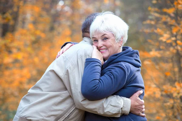 Mulher sênior abraça o homem e sorrindo — Fotografia de Stock