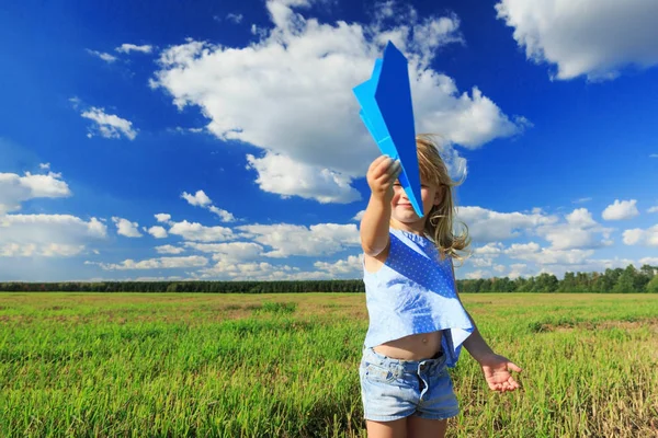 O fetiță care ține un avion de hârtie în mână . — Fotografie, imagine de stoc