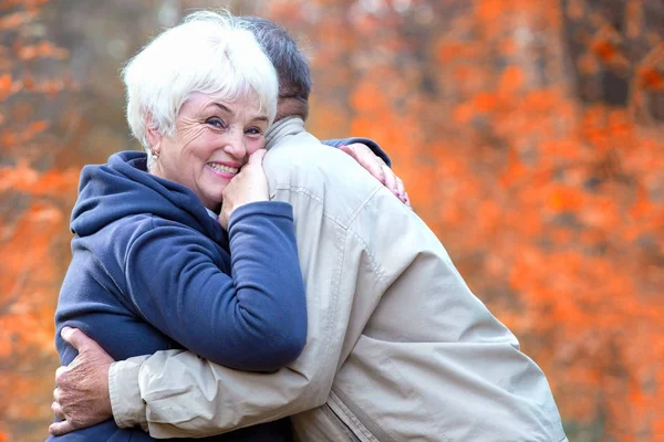 Mulher sênior abraça o homem e sorrindo — Fotografia de Stock