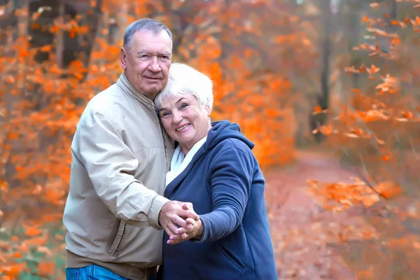 Feliz casal sênior abraços e olhando para câmera — Fotografia de Stock