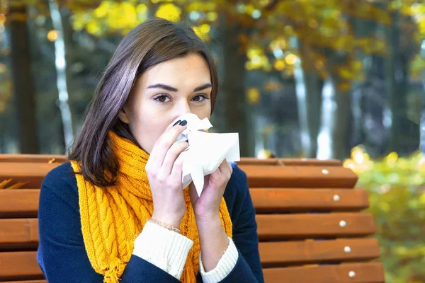 Wanita meniup hidung dengan tisu di taman — Stok Foto