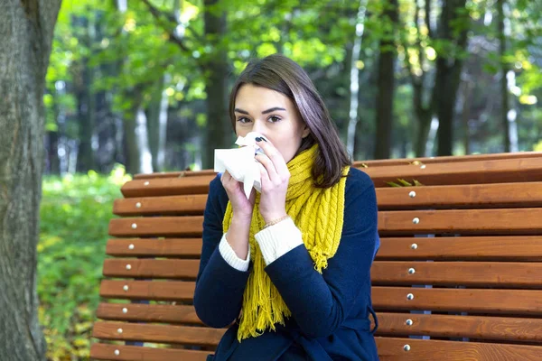 Wanita meniup hidung dengan tisu di taman — Stok Foto