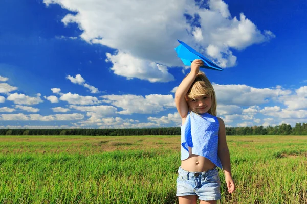 O fetiță care ține un avion de hârtie în mână . — Fotografie, imagine de stoc