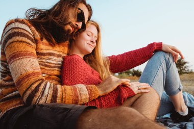 Erkek ve kadın ellerini bir arada tutan, Alyans ve hugg sunrise giyiyorlar. Ne kadar mutlu bir çift gibi görünüyor evli olduğunu.