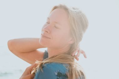 Genç güzel bir zarif ve doğal sarışın kadının mavi elbiseli deniz arka planda ile yakın çekim ortrait