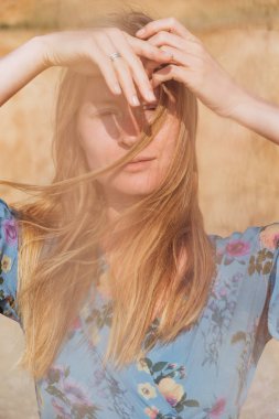 Bir güzel zarif ve doğal sarışın mavi elbiseli olan kadın arka planda sarı taş yakın çekim portresi