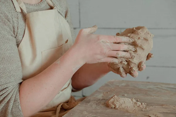 Primer plano manos femeninas mezclando bola de arcilla antes de trabajar en una rueda de cerámica — Foto de Stock