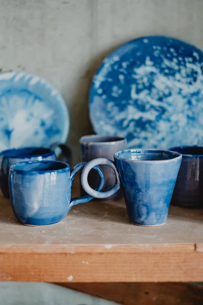 Close-up copos de cerâmica branca e azul e pratos nas prateleiras da loja de cerâmica — Fotografia de Stock