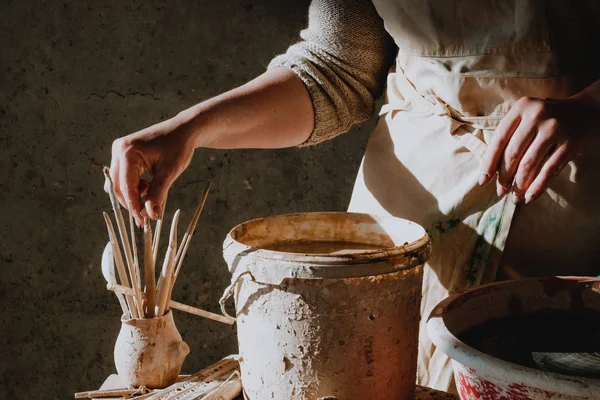 Primer plano manos femeninas instrumentos de tiro antes de trabajar en una rueda de cerámica — Foto de Stock