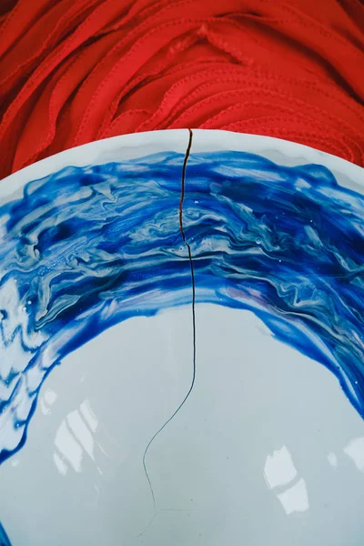 赤の背景に青と白のデザイン プレートにクローズ アップ亀裂 — ストック写真
