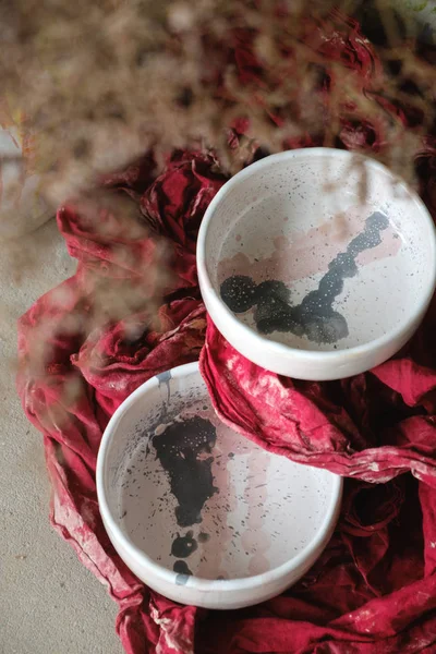 Close-up designer light painted ceramic bowls on red background — Stock Photo, Image