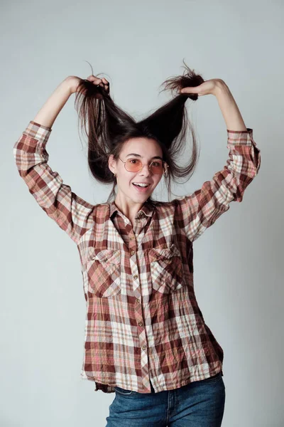 Bonito jovem morena menina no lenheiracheque camisa jogar com — Fotografia de Stock