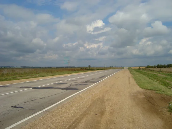 Route asphaltée directe à travers la campagne sous le ciel, sur wh — Photo