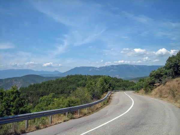 Carretera vacía en la zona montañosa sur en una calurosa cumbre —  Fotos de Stock