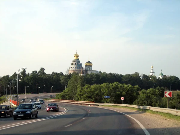 Estrada passando pelo mosteiro com um templo alto em um dia ensolarado . — Fotografia de Stock