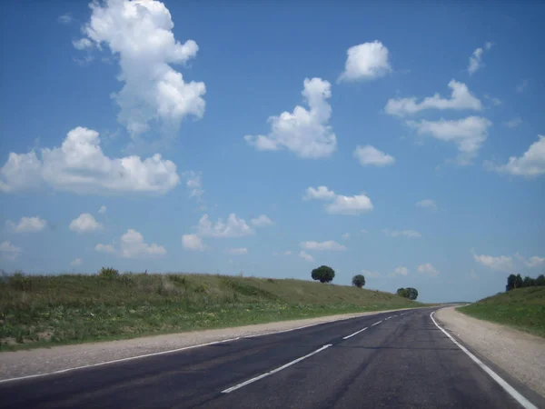 La carretera del coche en las grietas va lejos en la distancia en un br —  Fotos de Stock