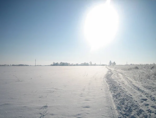 Winterliche Straße in einem sauberen flachen Feld an einem klaren frostigen Tag. — Stockfoto