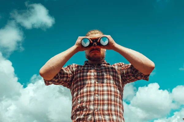 Macera arama kavramı. Dürbün gökyüzüne karşı mesafe bakarak sakallı keşfe çıkın. Düşük açılı noktası ateş