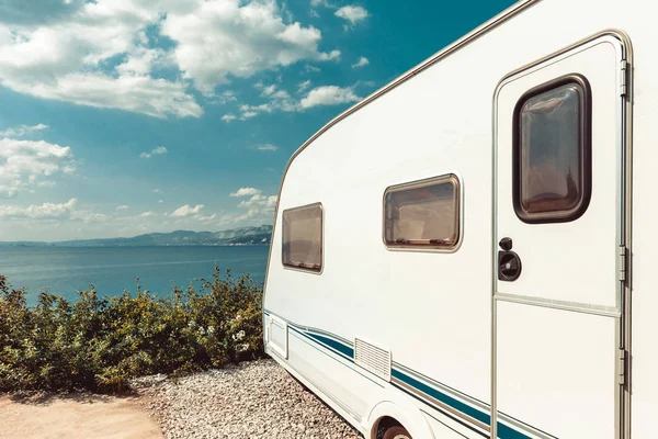 Deniz, plaj ve mavi gökyüzü yakın karavan römork. Yaz tatil yol yolculuk seyahat konsepti