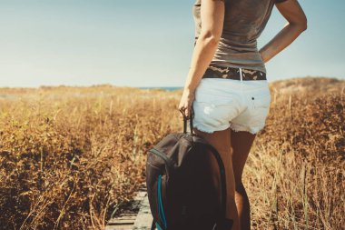 Tanınmayan kız gezgin bir sırt çantası içinde yaz, arkadan görünüş ile. Kavram yürümeye, tatil ve macera