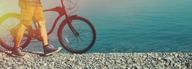 Onun bisiklet ile sahil sabahı yürüyen tanınmaz halde uzun yürüyüşe çıkan kimse adam