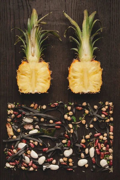 Food design minimalism flat lay. Cut along the pineapple and evenly spread out the beans, top view