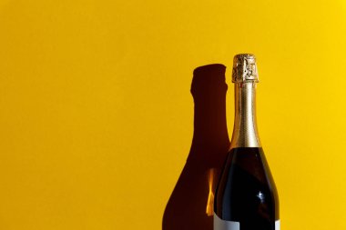 Neşeli Noel ve mutlu yeni yıl 2019 kavramı. Boşluk ile şişe şampanya sarı arka plan, düz üzerinde yatıyordu