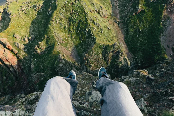 Gezgin bir uçurumun kenarında oturur. Adam bir dağ manzarası metrelik içinde belgili tanımlık geçmiş. Macera ve yaşam tarzı başarıları kavramı