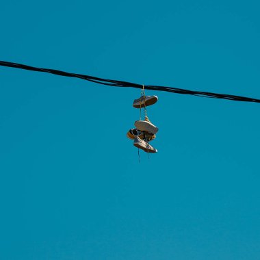 Bir gökyüzü arka plan üzerinde asılı spor ayakkabıları. Kentsel kultruta kavramı, satışı yasak maddeler, Getto