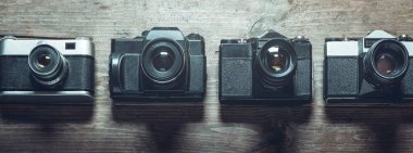 Ahşap bir yüzeyde tanınmayan film kameraları koleksiyonu. Fotoğraf Geliştirme Konsepti