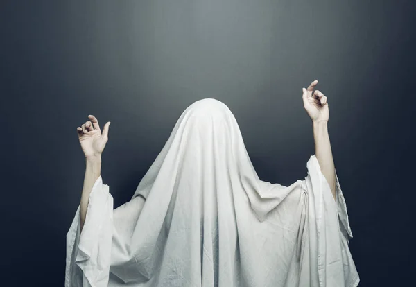 Menina em traje Fantasma branco assustador com olhos negros em um fundo cinza. Halloween conceito mínimo — Fotografia de Stock