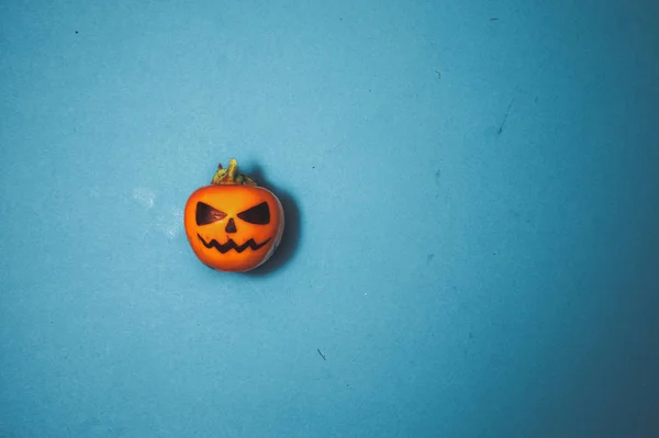 Halloween concept. Enge vakantie pompoen op een azuurblauwe achtergrond met ruimte voor tekst, bovenaanzicht vlak met krassen — Stockfoto