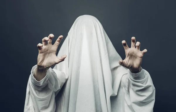 Espeluznante disfraz de fantasma blanco con ojos negros sobre un fondo gris. Halloween horror concepto mínimo — Foto de Stock