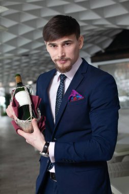 Genç erkek sommelier şarap tadımı restoranda sırasında bir şişe kırmızı şarap tutar