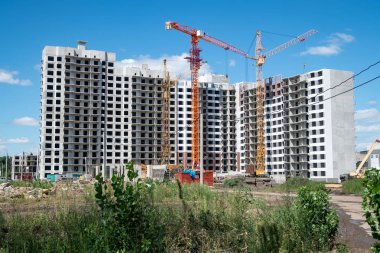 Güneşli bir günde inşa yüksek katlı inşaat alanında vinç ve İnşaat ekipmanları