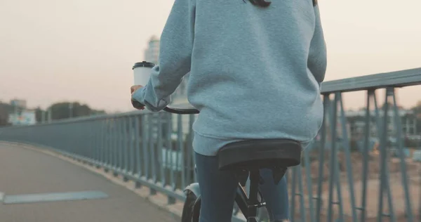 Junge Frau fährt mit Fahrrad in Stadtbrücke — Stockfoto