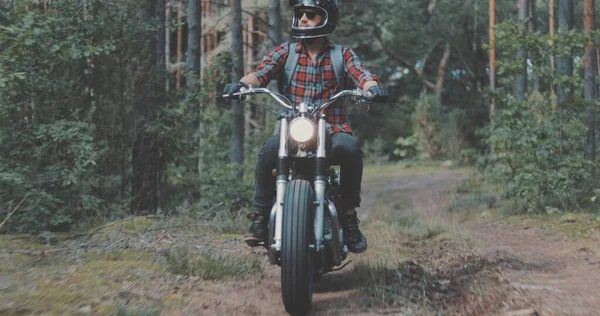 Młody motocyklista prowadzący motocykl po leśnej drodze — Zdjęcie stockowe