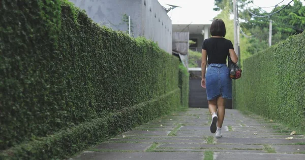 Mujer sostiene bolsa de compras de cuerda y camina —  Fotos de Stock