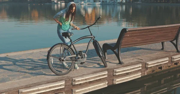 Женщина или девушка на велосипеде по набережной — стоковое фото