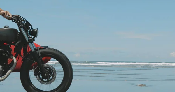 Motorkář řízení jeho motocykl na pláži — Stock fotografie