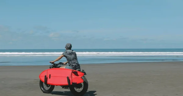 Motorrijder rijdt zijn motor op het strand — Stockfoto