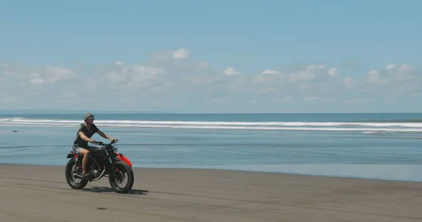 Motocyklista prowadzący motocykl na plaży — Zdjęcie stockowe