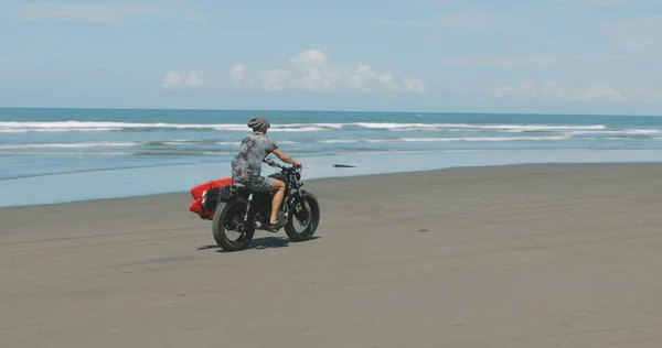 Motocycliste conduisant sa moto sur la plage — Photo