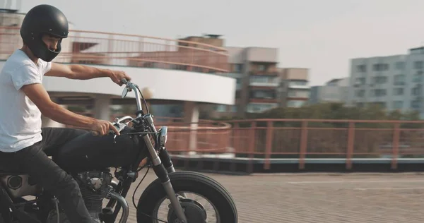 Biker riding on motorcycle in parking lot — Stock Photo, Image